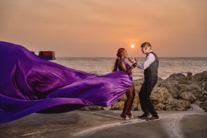 Couple dancing at sunset by ocean.