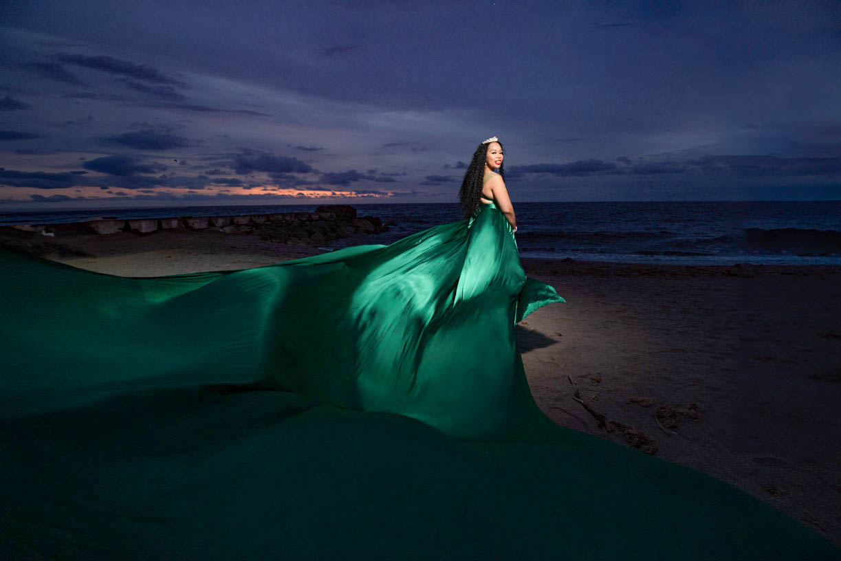 Flying Dress Cartagena photoshoot with a Woman in flowing green dress at beach