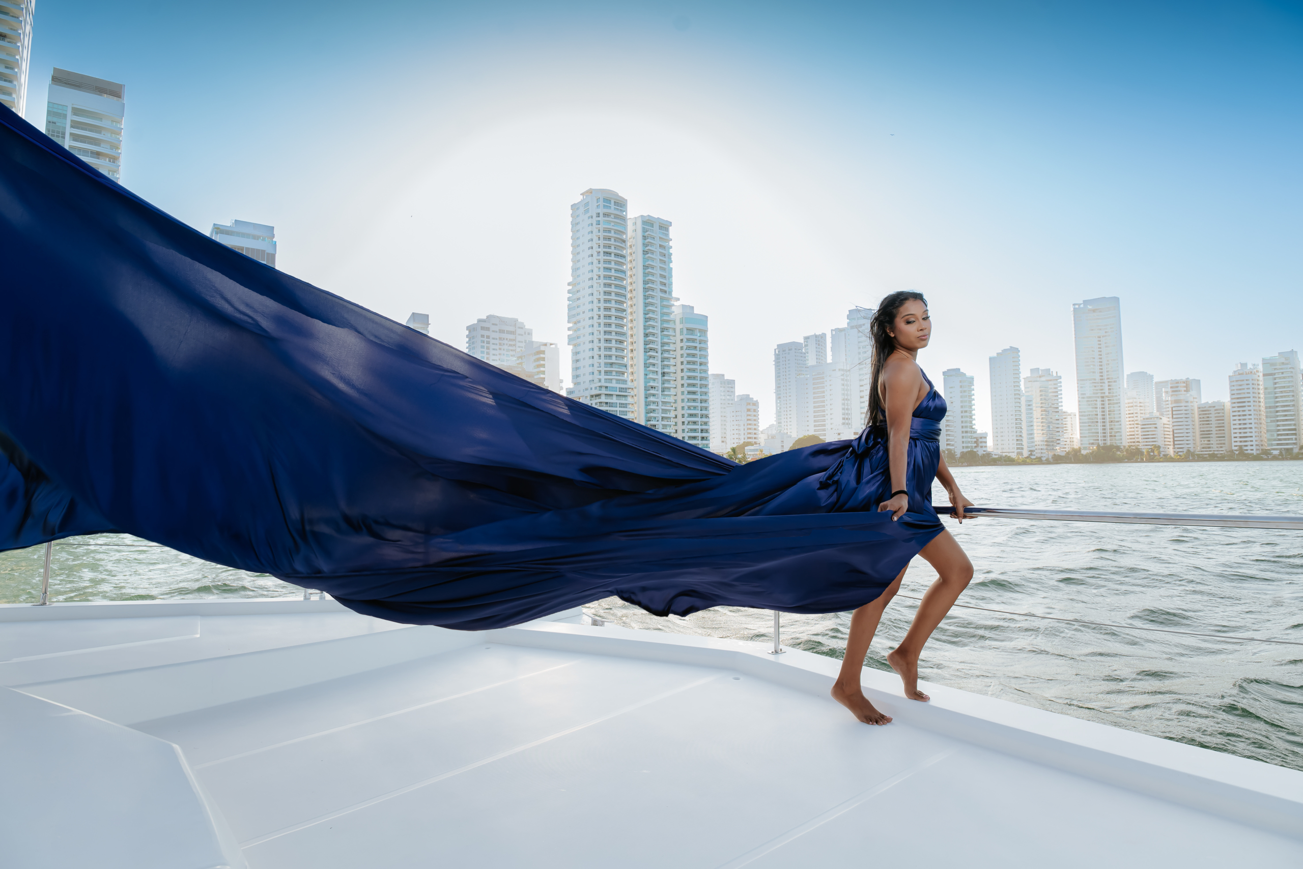 Navy flying dress photoshoot on a yacht in Cartagena Bay with the city skyline