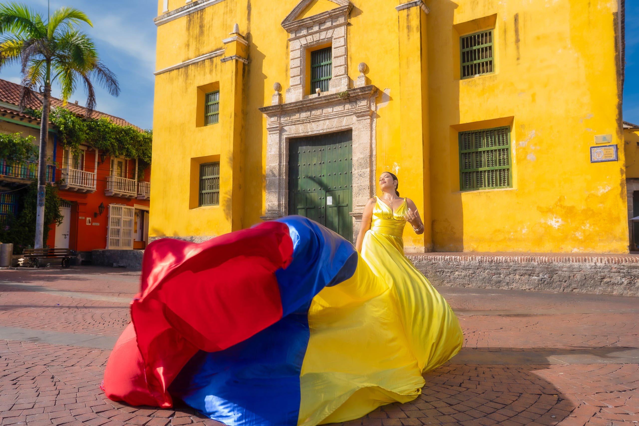 Flying dress photoshoot in front of a yellow colonial building in Getsemaní Cartagena